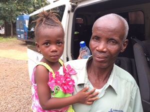 Pa Sanko, our intrepid driver, the man who has no fear, holding Augustine's older girl, Rachel.